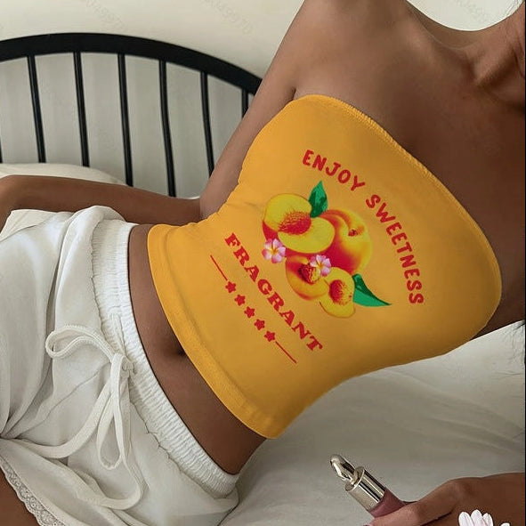 Person lying on a bed with a yellow top featuring a peach design and text