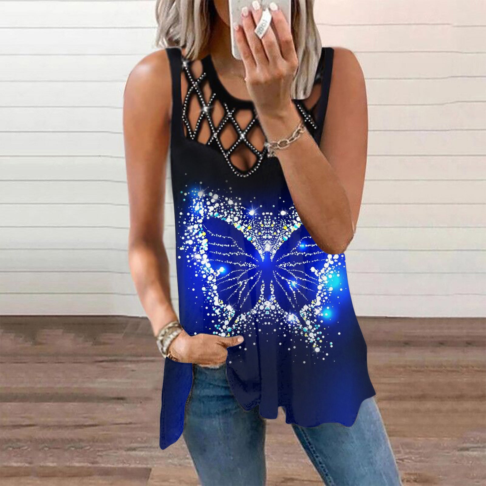 Woman wearing a black tank top with a blue butterfly design and denim jeans.