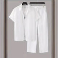 White shirt and pants set hanging on a rack against a neutral background