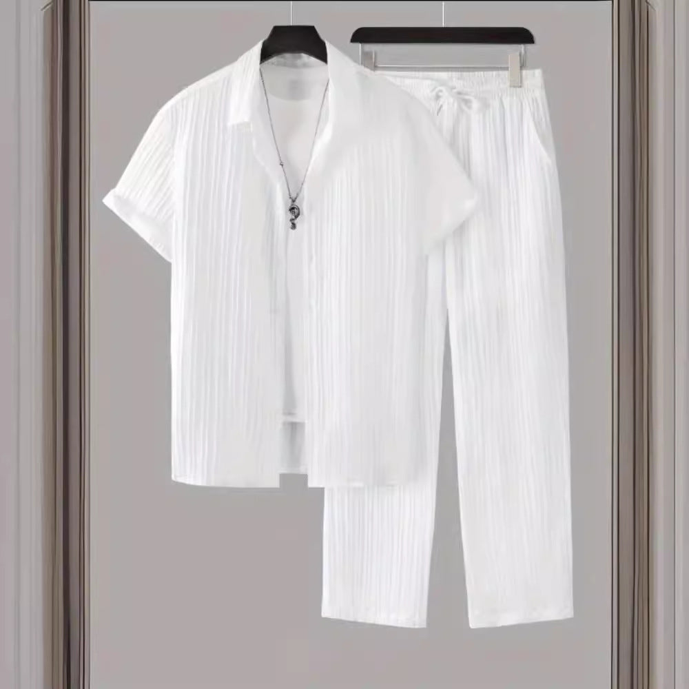 White shirt and pants set hanging on a rack against a neutral background