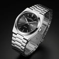 Silver watch with black dial on a dark background