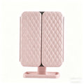 Pink quilted folding mirror on a white background