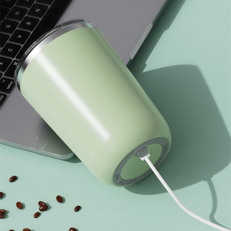 Light green USB device on a light green surface with a laptop and scattered beans.